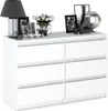 A white dresser with decorative items on top, including a lamp, flowers, and picture frames. Produktbild-Vorschau