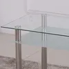 A close-up view of a glass table with metal legs. Náhľad obrázku produktu