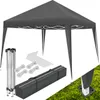 A dark gray pop-up gazebo and its accessories are laid out on a white background and a patch of grass. Náhled obrázku produktu