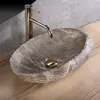 A close-up shot of a stone vessel sink with a gold faucet. Anteprima dell’immagine prodotto