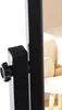 A close-up view of a black adjustable knob and part of a black metal frame, with a blurred background showing a chair and a patterned wall. Anteprima dell’immagine prodotto