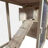 A close-up view of a wooden rabbit hutch, showing a ramp leading to an upper level. Voir les images du produit