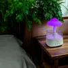 A mushroom-shaped humidifier with purple light sits on a wooden nightstand next to a bed, with lush green plants in the background. Náhled obrázku produktu