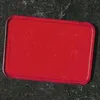 A red rectangular object with rounded corners is shown against a dark, textured background. Podgląd zdjęcia produktu