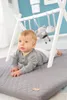 A baby is lying on a play mat under a play gym. Náhled obrázku produktu
