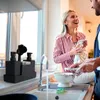 A couple is doing dishes in a kitchen, with the sink and dish soap dispenser visible. Produktbild-Vorschau