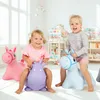 Two young children are playing with inflatable hopping animals in a bright, indoor play area. Produktbild-Vorschau