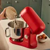 A person is adding flour to a red stand mixer. Voir les images du produit