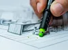 A hand is using a black and green marker to draw on a sketch. Anteprima dell’immagine prodotto