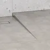 A close-up view of a shower drain with a metal profile on a tiled floor. Produktbild-Vorschau