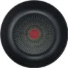 The bottom view of a black frying pan with a distinctive heat indicator in the center. Podgląd zdjęcia produktu