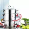 A multi-tiered stainless steel steamer pot with a red hose connected to a glass bottle, surrounded by fresh fruits and vegetables. Produktbild-Vorschau