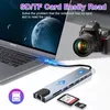 A laptop connected to a USB hub, with a camera in the background. Produktbild-Vorschau