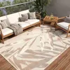 An outdoor patio setting with a sofa, chairs, and a coffee table on a wooden deck, featuring a large rug with a leaf pattern.