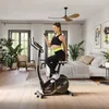 A woman is using a stationary bike in a bedroom. Podgląd zdjęcia produktu