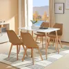 A dining set with a white table and four khaki chairs in a room with a window overlooking a lake and trees. Voir les images du produit