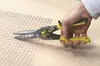 A hand is using tin snips to cut wire mesh. Anteprima dell’immagine prodotto