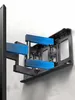 A close-up view of a black TV wall mount attached to a wall, with blue grid overlays highlighting its components. Náhľad obrázku produktu