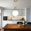 A modern kitchen with white cabinets, a marble backsplash, and a wooden dining table in the foreground. Voir les images du produit