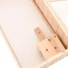 A close-up view of a wooden hamster cage interior, showing a hinged wooden ramp with carved notches. Produktbild-Vorschau