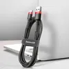 A black and red USB/USB-C charging cable is coiled and held by a strap with the brand name on it, leaning against a laptop. Náhľad obrázku produktu