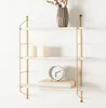 A three-tiered wall shelf with decorative items. Voir les images du produit