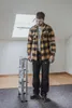 A man stands in a room with a skylight, next to a folded ladder. Produktbild-Vorschau