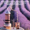 A copper distillation apparatus sits in front of rows of lavender fields, suggesting the origin of fragrance. Produktbild-Vorschau