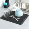 A dish drying mat with cups, a bowl, and forks next to a kitchen sink. Náhľad obrázku produktu