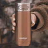 A hand holding a bronze Contigo travel mug with a silver lid. Produktbild-Vorschau