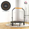 A fitness trampoline with a handle is shown in a room with wooden floors and a window in the background. Podgląd zdjęcia produktu