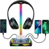 A headphone stand with integrated wireless charging and RGB lighting, displaying headphones, earbuds, and smartphones. Podgląd zdjęcia produktu