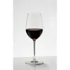 A single glass of red wine on a white surface. Produktbild-Vorschau