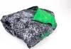 A folded blanket with a black and white pattern and a green section is shown against a white background. Náhľad obrázku produktu