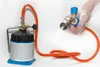 A hand holding a gas regulator connected to a gas canister with a hose. Podgląd zdjęcia produktu