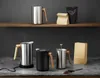 A collection of kitchen appliances and coffee-related items displayed on shelves and a countertop. Anteprima dell’immagine prodotto