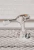 A cordless impact wrench with a socket attached, resting on a metal grate surface with a textured wall in the background. Produktbild-Vorschau