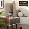 A weather station is placed on a nightstand next to a bed. Podgląd zdjęcia produktu