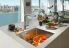 A modern kitchen sink with a faucet and a bowl of cherry tomatoes, with a city view in the background. Náhľad obrázku produktu