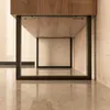 Close-up view of the bottom of a wooden cabinet with black metal legs, resting on a reflective marble floor. Produktbild-Vorschau