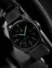 A close-up shot of a black Luminox watch with green luminous markers and hands, set against a dark, textured background. Voir les images du produit
