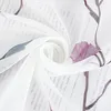 A close-up view of a white sheer fabric with a printed pattern of text and floral elements. Produktbild-Vorschau