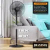 A black stand fan is shown in a living room setting next to a sofa, with graphic overlays highlighting its features. Voir les images du produit