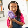 A young girl holding a purple plush toy. Náhled obrázku produktu