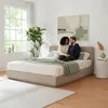 A couple sitting on a bed in a bedroom. Produktbild-Vorschau