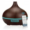 A dark wood-grain aroma diffuser with a blue LED light strip and a remote control. Produktbild-Vorschau