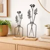 Two decorative metal vases with artificial flowers on a wooden surface. Produktbild-Vorschau