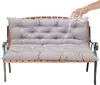 A hand is pouring water onto a grey bench cushion to demonstrate its water-repellent properties. Voir les images du produit