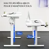 Two white adjustable standing desks are shown in a room with a gray carpet. The desk on the left is at a higher position than the desk on the right. Both desks have computers and accessories on them. Text overlays indicate adjustable height ranges. Voir les images du produit
