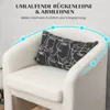 Close-up of a white armchair with a decorative pillow. Produktbild-Vorschau